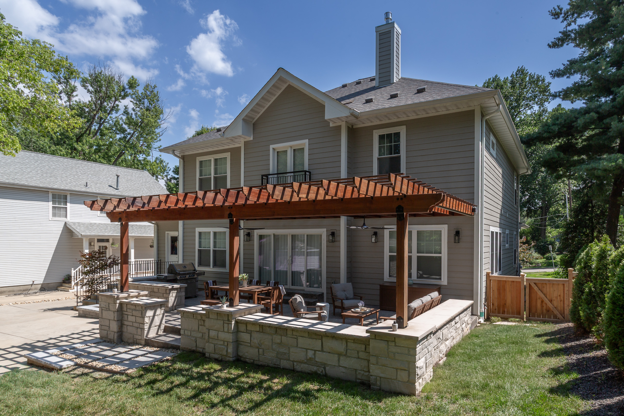 Wide shot - Exterior of home with Pergola and patio built by Rosette Forever Homes